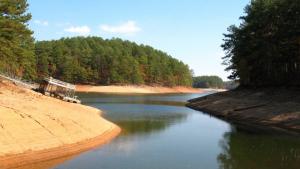 Dock and boat on dry lake bottom, with water in small area