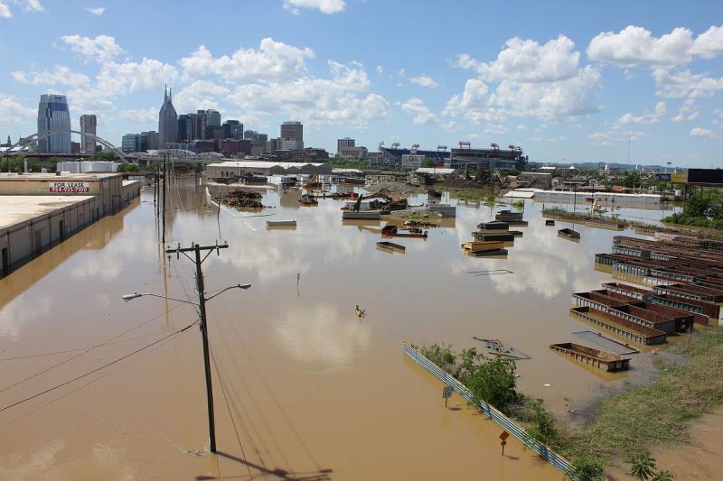 Flooding of industrial area with high-rise buildings in background
