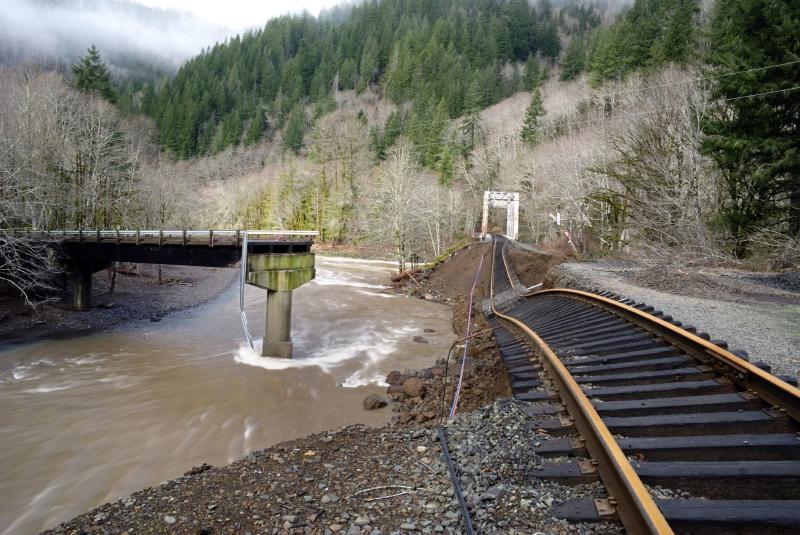 A failed bridge and sagging railroad tracks, undermined by erosion from flooding