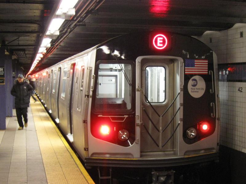 Photo of subway train and customers on a station platform