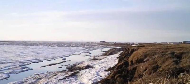 Open water and ice along a bluff of land